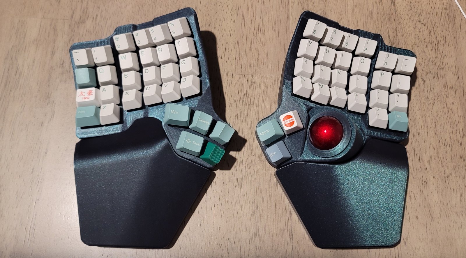 My new split keyboard fully put together with clean, white keycaps and a bright red trackball